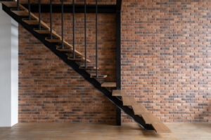 Modern stairs in room with brick wall