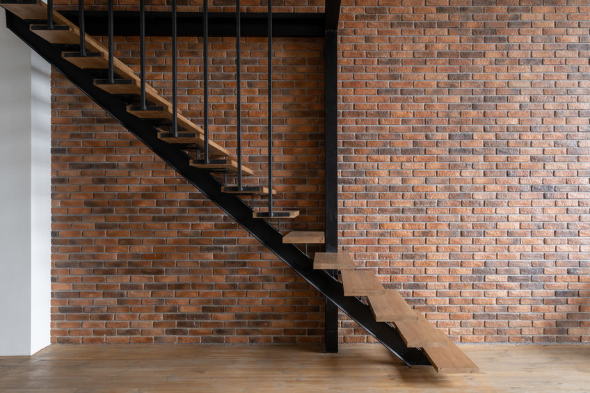 Modern stairs in room with brick wall